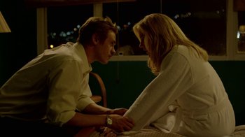 Movie still from “Narcos” (2015), created by Chris Brancato – A man and a woman sitting on a chair; Medium shot, Low angle