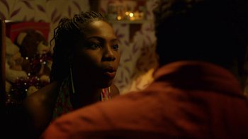 Movie still from “Narcos” (2015), created by Chris Brancato – A woman sitting in front of another person; Close Up shot, Over the shoulder angle