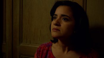 Movie still from “Narcos” (2015), created by Chris Brancato – A person sitting in front of a wooden wall; Close Up shot, Low angle