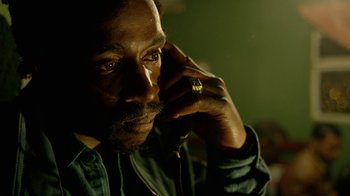 Movie still from “Narcos” (2015), created by Chris Brancato – A person with a cell phone to his ear; Close Up shot, High angle