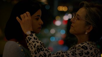 Movie still from “Narcos” (2015), created by Chris Brancato – A woman putting a face mask on another woman's face; Close Up shot, Over the shoulder angle