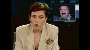 Movie still from “Narcos” (2015), created by Chris Brancato – A woman sitting in front of a man with moustaches; Close Up shot, High angle