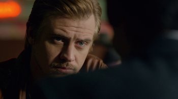 Movie still from “Narcos” (2015), created by Chris Brancato – A person with a beard looking at something; Close Up shot, Over the shoulder angle