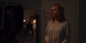 Movie still from “Midsommar” (2019), directed by Ari Aster – A woman standing in front of a mirror in a room; Medium shot, Over the shoulder angle