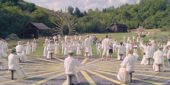Movie still from “Midsommar” (2019), directed by Ari Aster – A group of people dressed in white are standing in a circle; Extreme Wide shot, High angle