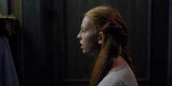 Movie still from “Midsommar” (2019), directed by Ari Aster – A woman with long red hair is looking to the side; Close Up shot, Low angle