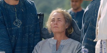 Movie still from “Midsommar” (2019), directed by Ari Aster – An older woman sitting in a chair with her eyes closed; Close Up shot, Over the shoulder angle