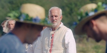 Movie still from “Midsommar” (2019), directed by Ari Aster – An older man wearing a white shirt and tie; Close Up shot, Low angle