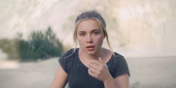 Movie still from “Midsommar” (2019), directed by Ari Aster – A young blonde haired woman in a black shirt; Close Up shot, High angle