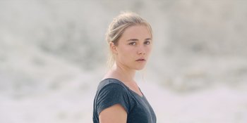Movie still from “Midsommar” (2019), directed by Ari Aster – A young woman is looking into the distance; Close Up shot, Over the shoulder angle