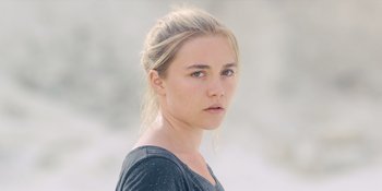 Movie still from “Midsommar” (2019), directed by Ari Aster – A woman with blonde hair and a black shirt; Close Up shot, Over the shoulder angle