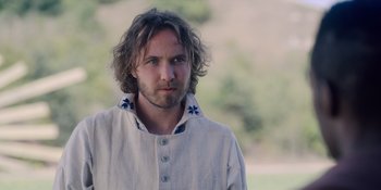 Movie still from “Midsommar” (2019), directed by Ari Aster – A person with long curly hair; Close Up shot, Over the shoulder angle