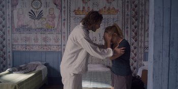 Movie still from “Midsommar” (2019), directed by Ari Aster – A man and a woman are standing in front of a bed; Medium shot, Over the shoulder angle
