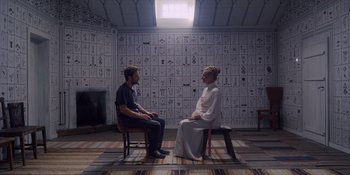 Movie still from “Midsommar” (2019), directed by Ari Aster – A man and a woman sitting on chairs in front of each other; Wide shot, Over the shoulder angle