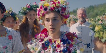 Movie still from “Midsommar” (2019), directed by Ari Aster – A woman wearing a floral dress and a flower crown; Close Up shot, Over the shoulder angle