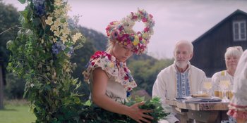 Movie still from “Midsommar” (2019), directed by Ari Aster – A woman wearing a wreath of flowers on her head; Medium shot, Low angle