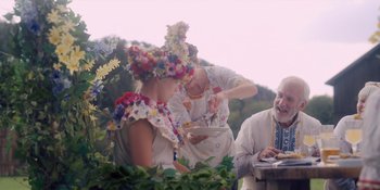 Movie still from “Midsommar” (2019), directed by Ari Aster – Two women and a man are dressed in traditional ukrainian garb; Medium shot, Over the shoulder angle