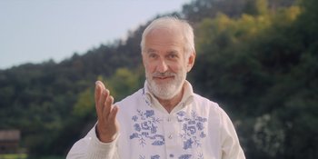 Movie still from “Midsommar” (2019), directed by Ari Aster – An older man with a white beard waving; Close Up shot, Low angle