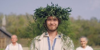 Movie still from “Midsommar” (2019), directed by Ari Aster – A man wearing a wreath of leaves on top of his head; Close Up shot, Over the shoulder angle