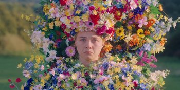 Movie still from “Midsommar” (2019), directed by Ari Aster – A woman in a flower crown is surrounded by flowers; Close Up shot, High angle