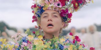 Movie still from “Midsommar” (2019), directed by Ari Aster – A woman wearing a floral headpiece and a green dress; Close Up shot, Low angle