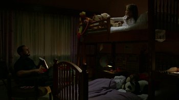 Movie still from “Narcos” (2015), created by Chris Brancato – A girl reading a book in a bedroom; Wide shot, High angle