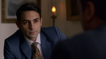 Movie still from “Narcos” (2015), created by Chris Brancato – A man wearing a suit and tie sitting in front of a mirror; Close Up shot, Over the shoulder angle