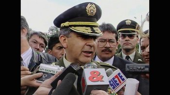 Movie still from “Narcos” (2015), created by Chris Brancato – A man in a military uniform talking to reporters; Close Up shot, Low angle