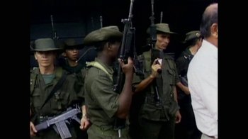 Movie still from “Narcos” (2015), created by Chris Brancato – A group of men standing next to each other holding guns; Medium shot, Low angle
