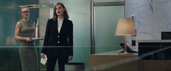 Movie still from “Miss Sloane” (2016), directed by John Madden – A woman in a suit stands in front of a mirror in a room; Medium shot, Low angle