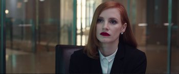 Movie still from “Miss Sloane” (2016), directed by John Madden – A person sitting in a chair wearing a suit; Close Up shot, Over the shoulder angle