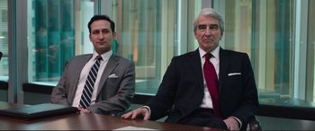 Movie still from “Miss Sloane” (2016), directed by John Madden – Two businessmen sitting at a table in front of a window; Medium shot, Low angle