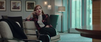 Movie still from “Miss Sloane” (2016), directed by John Madden – A woman sitting on a chair in a room; Medium shot, Low angle