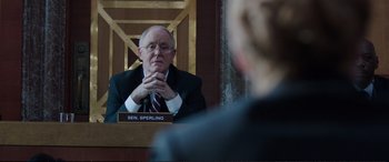 Movie still from “Miss Sloane” (2016), directed by John Madden – A man sitting in front of another man in front of him; Medium shot, Over the shoulder angle