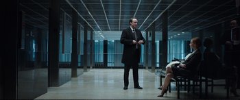 Movie still from “Miss Sloane” (2016), directed by John Madden – A man in a suit and tie standing next to a woman; Wide shot, Low angle