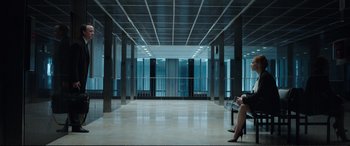 Movie still from “Miss Sloane” (2016), directed by John Madden – A person sitting on a bench in a large room; Extreme Wide shot, High angle