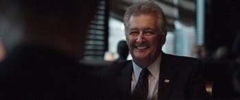 Movie still from “Miss Sloane” (2016), directed by John Madden – An older man wearing a suit and tie; Close Up shot, Over the shoulder angle