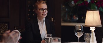 Movie still from “Miss Sloane” (2016), directed by John Madden – A woman sitting at a table with a glass of water; Close Up shot, Over the shoulder angle