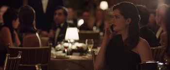 Movie still from “Miss Sloane” (2016), directed by John Madden – A woman sitting at a table talking on a phone; Medium shot, Over the shoulder angle