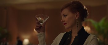 Movie still from “Miss Sloane” (2016), directed by John Madden – A woman holding up a martini glass in a dark room; Close Up shot, Low angle