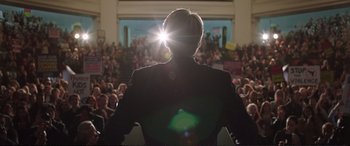 Movie still from “Miss Sloane” (2016), directed by John Madden – A person standing in front of an audience; Medium shot, Low angle