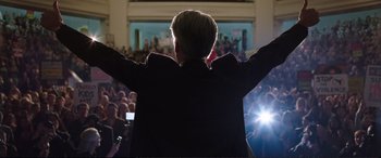 Movie still from “Miss Sloane” (2016), directed by John Madden – A man with his arms outstretched in front of a crowd; Medium shot, Low angle