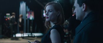 Movie still from “Miss Sloane” (2016), directed by John Madden – A woman in a black dress looking to her left; Close Up shot, Over the shoulder angle