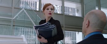 Movie still from “Miss Sloane” (2016), directed by John Madden – A woman holding a stack of folders in her hands; Medium shot, Low angle