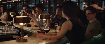 Movie still from “Miss Sloane” (2016), directed by John Madden – A group of people sitting at a table drinking wine; Medium shot, Over the shoulder angle