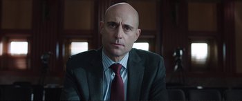 Movie still from “Miss Sloane” (2016), directed by John Madden – A man in a suit and tie sitting in front of a window; Close Up shot, Low angle