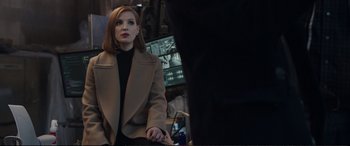 Movie still from “Miss Sloane” (2016), directed by John Madden – A woman in a brown coat standing in front of a mirror; Medium shot, Over the shoulder angle