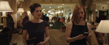 Movie still from “Miss Sloane” (2016), directed by John Madden – Two women are standing in a room talking; Medium shot, Over the shoulder angle
