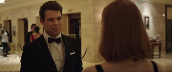 Movie still from “Miss Sloane” (2016), directed by John Madden – A man in a tuxedo looking at a woman in front of a mirror; Close Up shot, Over the shoulder angle