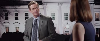 Movie still from “Miss Sloane” (2016), directed by John Madden – A man in a suit and tie talking to a woman in front of a white building; Medium shot, Over the shoulder angle